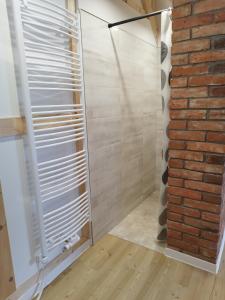 a shower with a glass door next to a brick wall at Kleine Auszeit 1 in Forst +6 photos