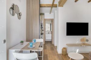 a living room with a table and chairs and a tv at Apartamentos Habana 5 in Barbate