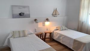 a bedroom with two beds and a small table at Miret in Cala en Bosc +13 photos