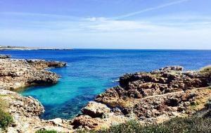 a large body of water with rocks and the ocean at Miret in Cala en Bosc