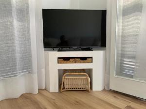 a flat screen tv sitting on a white stand in a room at Miret in Cala en Bosc