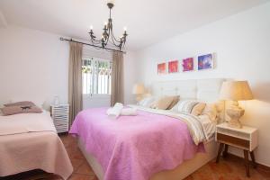 a bedroom with two beds and a chandelier at Villa Costabella in Marbella +25 photos