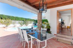 a dining room with a table and chairs on a patio at Villa Costabella in Marbella