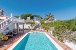 a swimming pool in the backyard of a house at Villa Costabella in Marbella