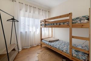 a bedroom with two bunk beds and a window at Vitóriahouse - Your Little Corner in Vila Nova de Gaia