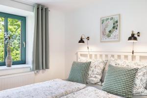 sypialnia z łóżkiem z poduszkami i oknem w obiekcie Ferienwohnung Villa Funcke w mieście Eisenach