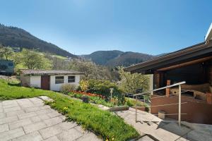 a garden in front of a house with mountains in the background at Ferienwohnung Gabriele in Lauf