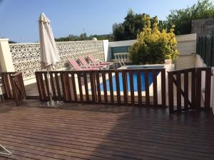 a deck with chairs and an umbrella and a pool at Sitges Llum House in Sitges +30 photos