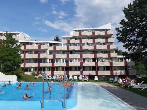 a hotel with people in a swimming pool in front of a building at Ferienwohnung Manuela in Sankt Englmar
