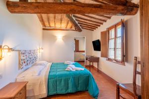 a bedroom with a bed with a green comforter at Agriturismo la Taverna Di Celsa in Sovicille +118 photos