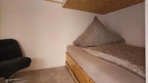 a small bedroom with a bed and a chair at Waldhaus Hempe in Tabarz