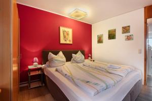 a bedroom with a red wall with a bed at Ferienwohnung Manuela in Sankt Englmar +30 photos