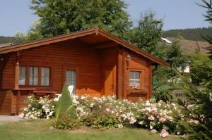 a log cabin with flowers in front of it at Ferienhaus Pöttgen in Arnsberg