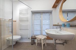a bathroom with a sink and a toilet and a mirror at Ferienwohnungen in Neufeld in Neufeld +49 photos