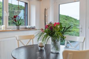 a table with a vase of flowers on it at Ferienwohnungen in Neufeld in Neufeld