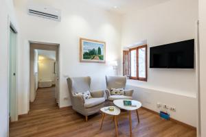 a living room with two chairs and a tv at Il Teatro in San Gimignano