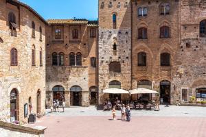 a group of people standing in front of a large brick building at Il Teatro in San Gimignano