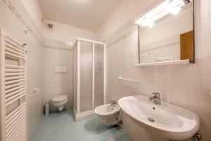 a white bathroom with a sink and a toilet at Villa Mazzel - Cima 12 in Vigo di Fassa +14 photos