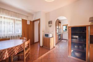 a kitchen and dining room with a table and a microwave at Villa Mazzel - Cima 12 in Vigo di Fassa