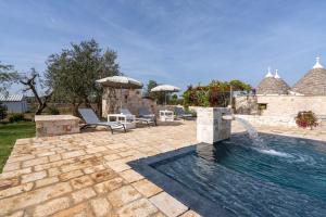 a swimming pool with a fountain in a yard at Trulli Orma in Martina Franca