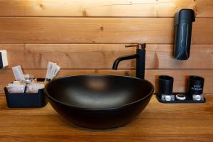 a black bowl sink sitting on top of a counter at Les Chalets De Tesa in Occhiatana