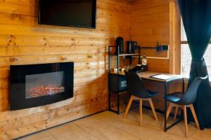 a room with a fireplace and a desk and chairs at Les Chalets De Tesa in Occhiatana