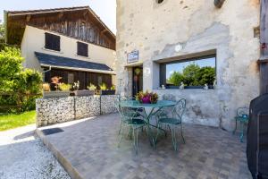 a patio with a table and chairs in front of a building at Gîte L'étable in Sales