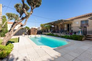 a swimming pool in a yard next to a house at Villa Salamandre in Port-Saint-Louis-du-Rhône