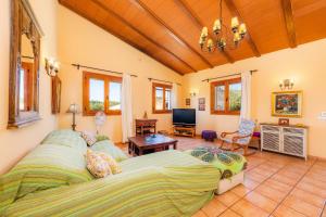 a bedroom with two beds and a living room at Can Colau in Santa Margalida