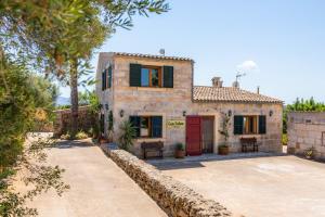 a large stone house with a red door at Can Colau in Santa Margalida
