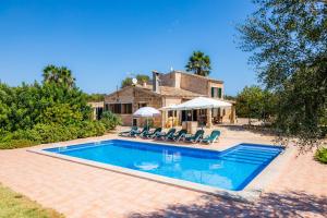 a swimming pool with chairs and a house at Can Colau in Santa Margalida