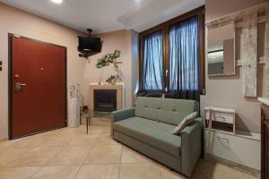 a living room with a green couch and a door at La Casa di Lu - Val D'Intelvi in Lanzo dʼIntelvi