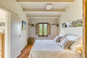 a bedroom with a bed and a window at El Pedró Panoramic in Ventalló