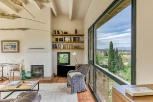 a living room with a fireplace and a large window at El Pedró Panoramic in Ventalló