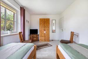 a bedroom with two beds and a television in it at Ferienwohnung Anke Volkmann in Offenbüttel
