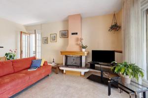 a living room with a red couch and a fireplace at Appartamento Marilu Lake View in Brenzone sul Garda