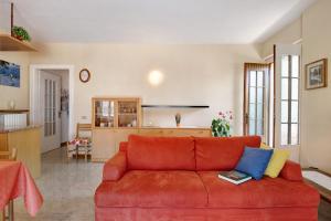 a living room with a red couch and a kitchen at Appartamento Marilu Lake View in Brenzone sul Garda