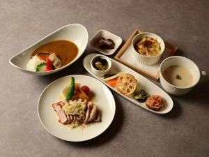 a table with plates of food and bowls of food at Lit Hotel NAKIJIN in Nakijin