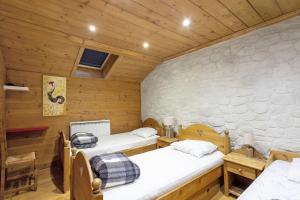 a room with two beds and a stone wall at Maison de village Puyvalador in Puyvalador