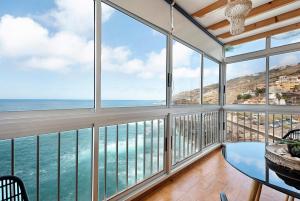 a room with large windows and a view of the ocean at Marazul in Tacoronte