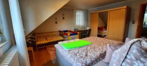 a bedroom with a crib with a green pillow on a bed at Ferienwohnung an der Lahn in Limburg an der Lahn