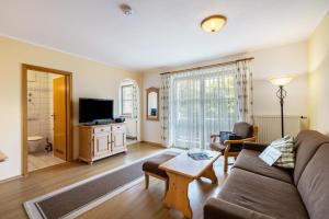 a living room with a couch and a tv at Fewo Brünnstein - Nr 61 Pool, Sauna in Oberaudorf