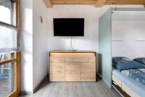 a bedroom with a flat screen tv on a wall at Ferienwohnung Geyersberg 704 in Hauzenberg