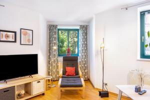 salon z telewizorem i krzesłem w obiekcie Ferienwohnung Villa Funcke w mieście Eisenach