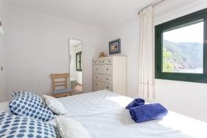 a bedroom with a white bed with a window at Villa Banyalbufar in Banyalbufar