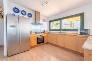 a kitchen with a stainless steel refrigerator and a window at Villa Banyalbufar in Banyalbufar
