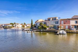 a view of a river with houses and a dock at Petite maison Aigues Mortes in Aigues-Mortes