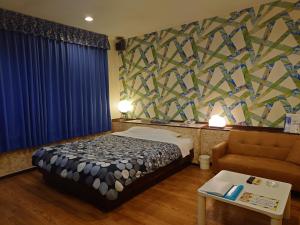 a hotel room with a bed and a couch at Hotel SOGNA ソニアAdultOnly in Miyaki