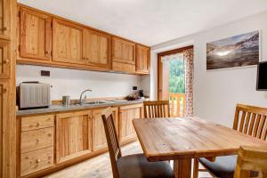 a kitchen with wooden cabinets and a wooden table at Aux Pieds du Malatra' 2 in Saint-Rhémy-en-bosses
