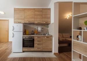 a kitchen with wooden cabinets and a white refrigerator at Apartments Viktoria in Tivat